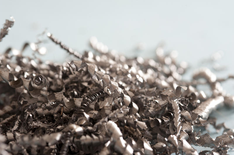 Pile of spiral metal shavings after machining during production in a close up view with copy space above