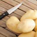 17254   Close up of potatoes and knife on timber bench
