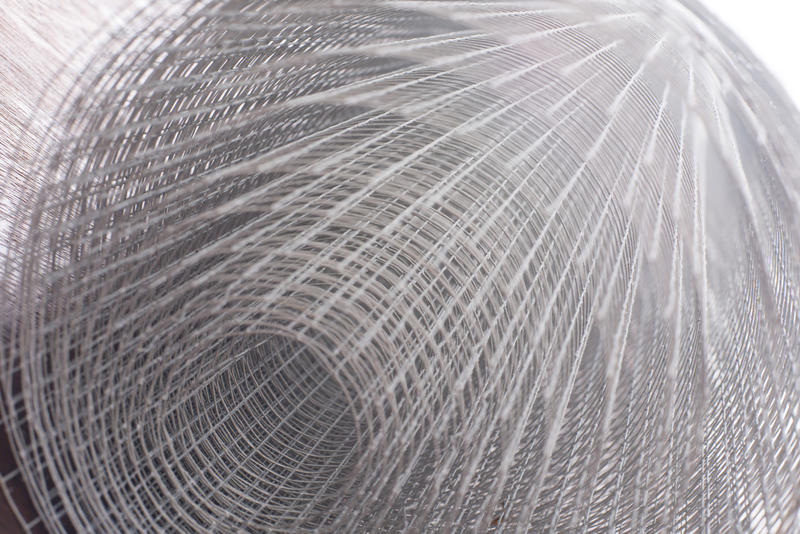 Large roll of metal mesh viewed from the end for security fencing in a receding perspective