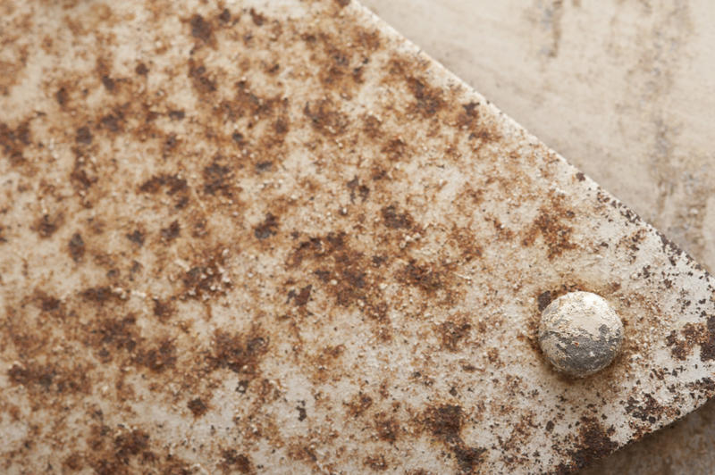 Old weathered rusty white painted metal surface with flaking paint covered in corrosion in a full frame background texture