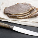 17266   Sliced roast beef on paper and kitchen knife