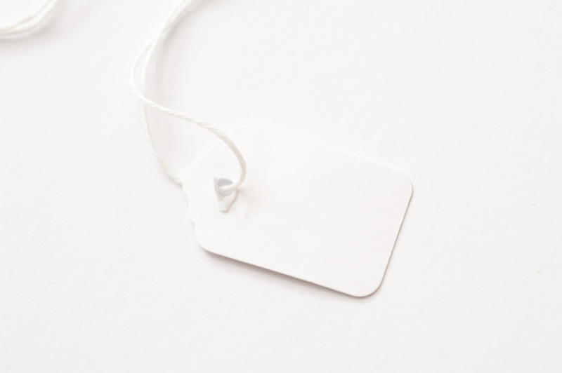 White price tag label on a thread placed on white background and viewed in close-up