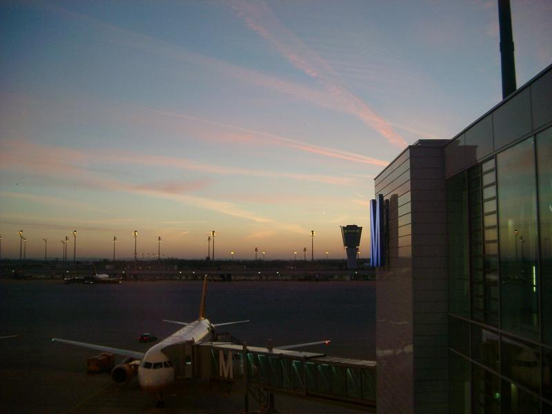 passenger plane at an airport terminal gate at sunset