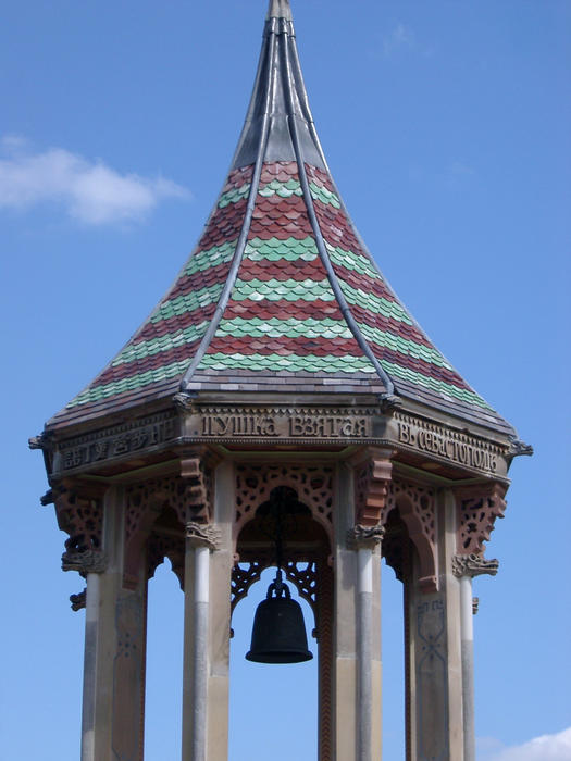 an ornate commemorative bell tower with tiled shingle pattern roof