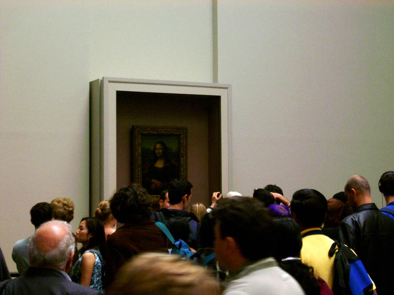 a crowed of people around the famous mona lisa