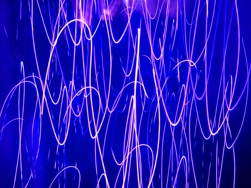 abstract background of curving and crossing purple light trails