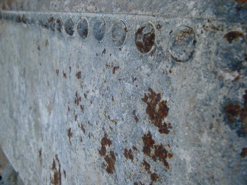 rivents and rust forming on an old metal water tank