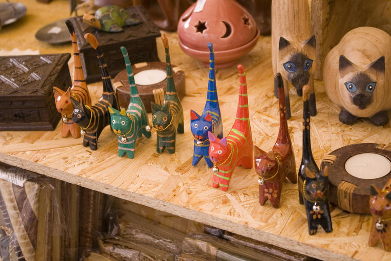 a craft shop display of wooden carved cats
