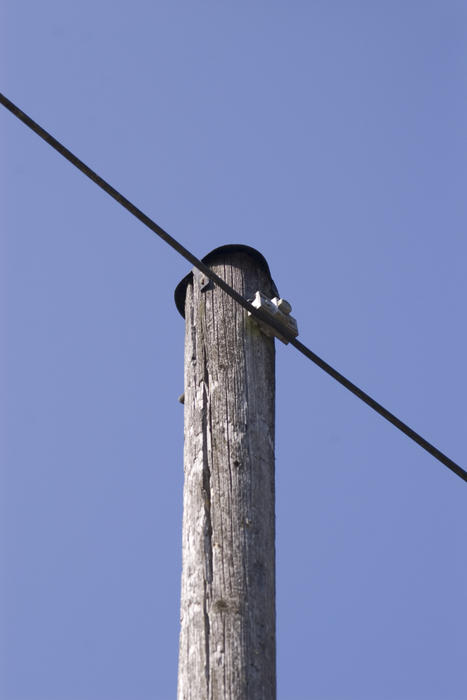 an aerial phone line on a wooden pole