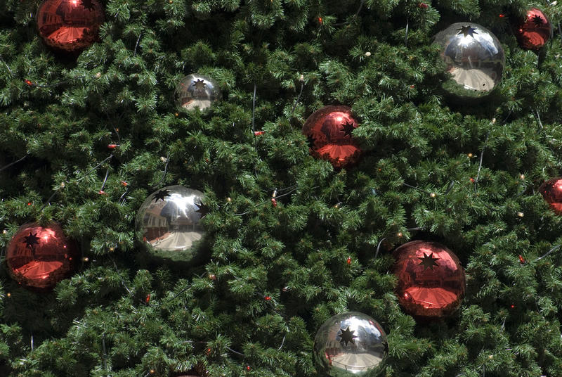 Silver and red metalic christmas baubles on a synthetic christmas tree