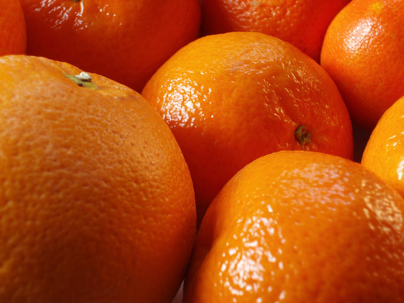 a bowl of ripe oranges sgowing the details of citrus fruit skin