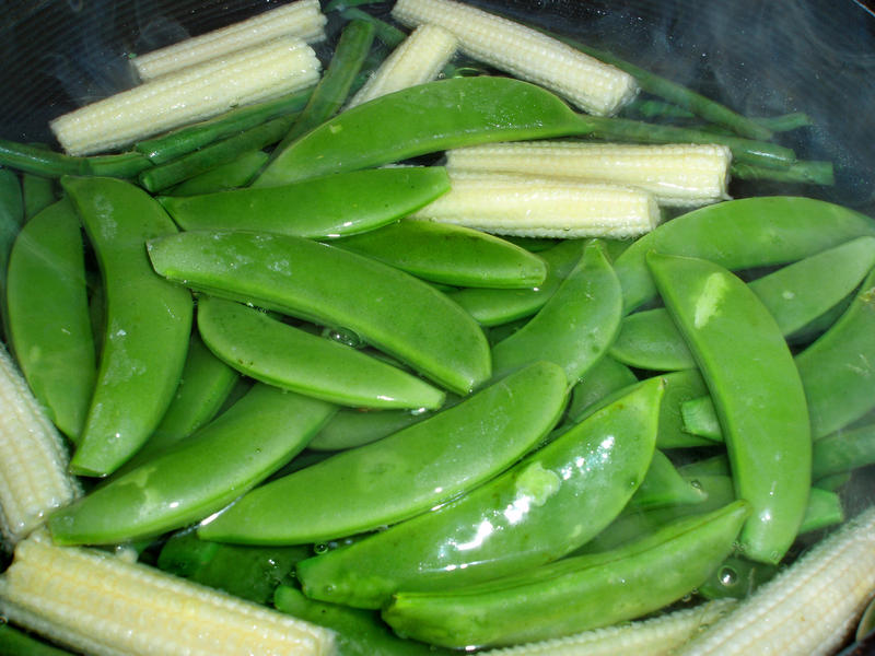 a pan with boiling water, cooking green beans and baby sweetcorn