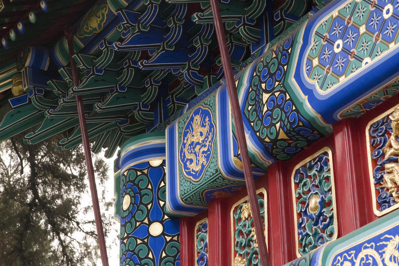 close up on the carvings and paintwork of a traditional chinese archway gate