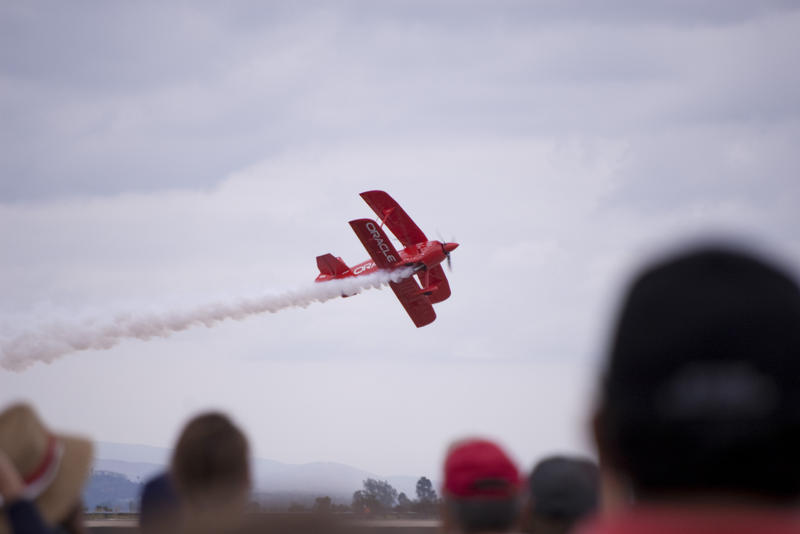 a red coloured stunt plane performing an airshow display