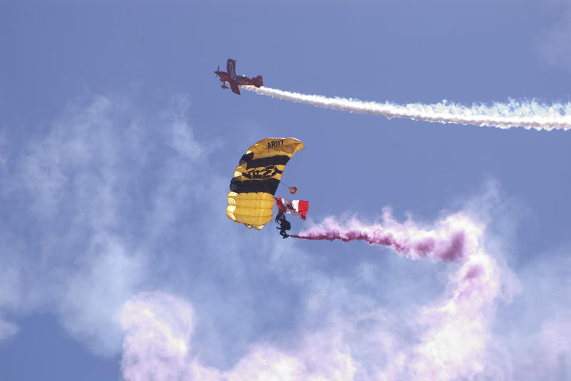 a plain and parachutist at an air show
