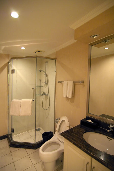 a clean modern bathroom with shower, toilet and wash basin