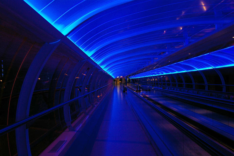 blue lit bridge walkway at manchester airport uk