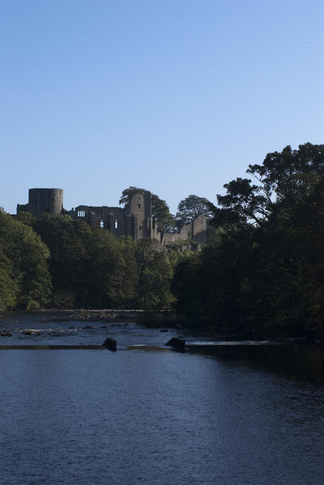 looking across a river at a ruined english castle
