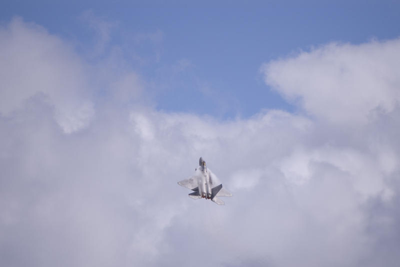 Lockheed Martin F-22 Raptor Aircraft performing a steep climb and creating vapour trails from the leading edges of its wings