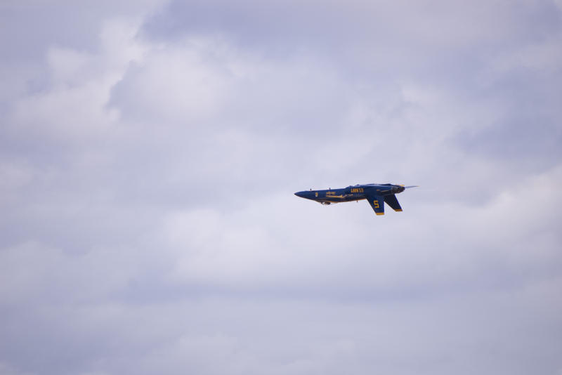 a navy blue angel stunt pilot flying upsidedown