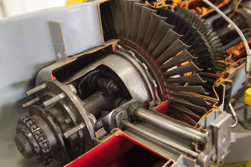 a jet engine with cut away sections to see the turbine blades inside