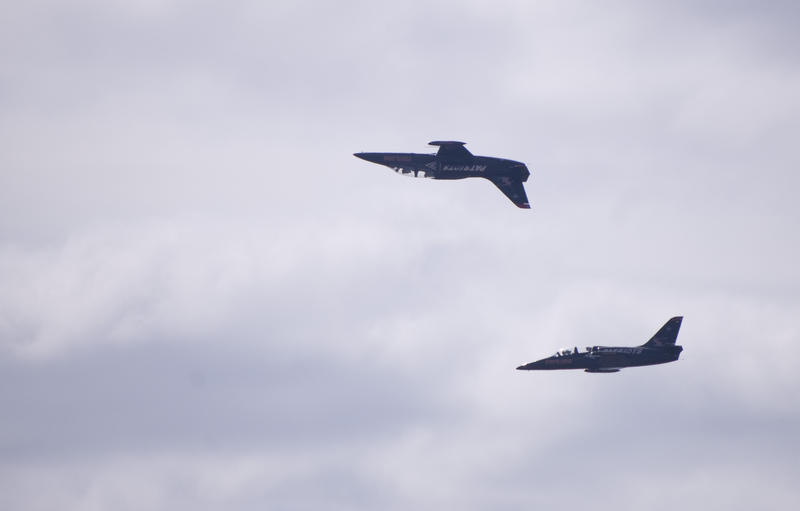 the patriots jet team performing an air show flypast with one plane flying inverted