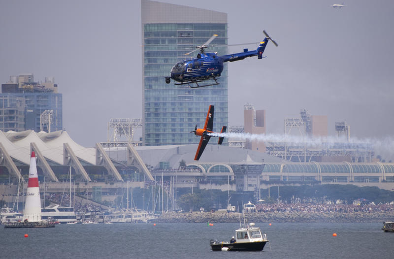 editorial use only : red bull air race san diego, a plane makes a sharp turn filmed by a camera helicopter
