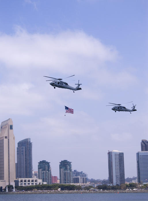 helicopters flying the american flag over the san diego waterfront