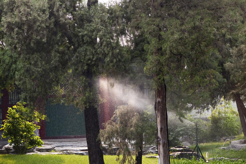 a sprinkler watering plants in a beijing park