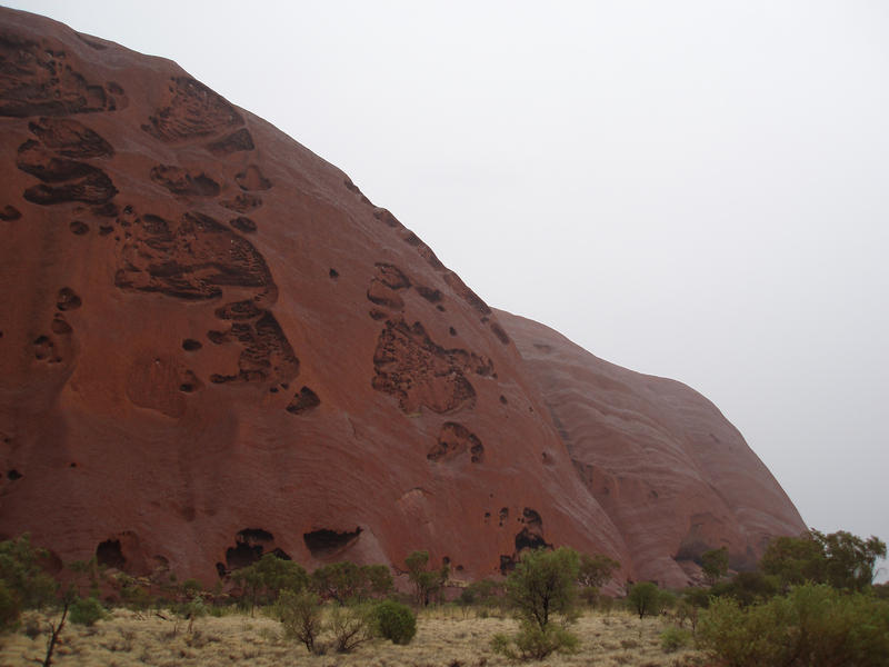 the side of uluru (ayres rock) on a rainy day
