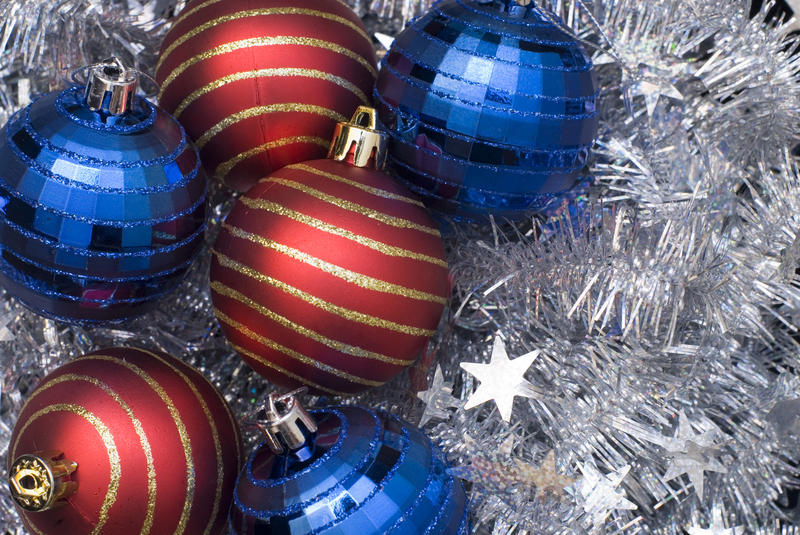 an assortment of reflective christmas ornaments on a background of silver tinsel