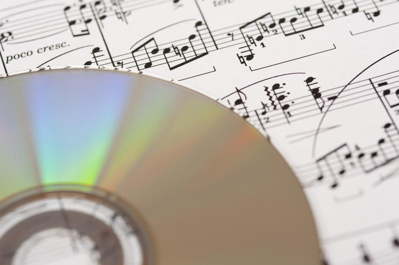 a compact disk laying on a background of sheet music