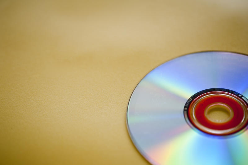 an audio compact disc on a yellow backdrop