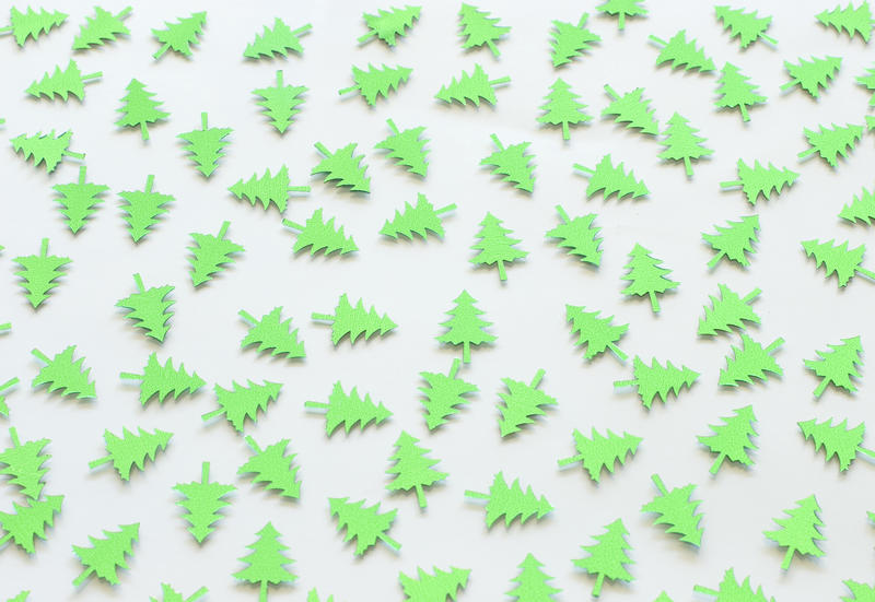 a background of randomly scattered green christmas pine tree shapes