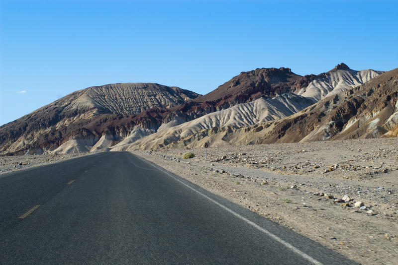 colourful eroded rock formations line the sides of the highway near death valley, california