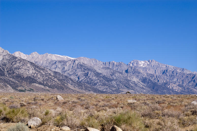 a flat desert landscape with mountains in the distance, near mount whitney, california