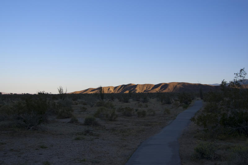 last light of the day illuminates a rocky range in the california desert