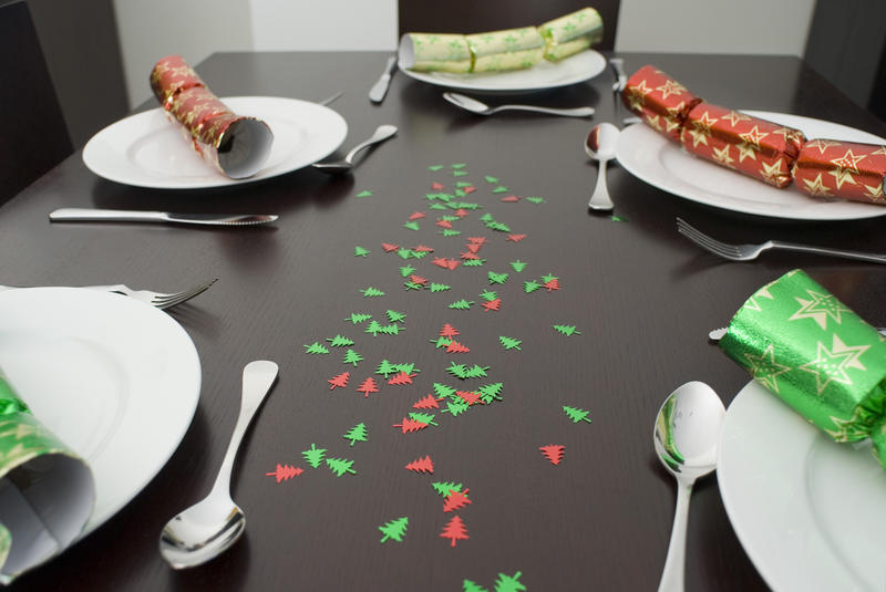 a modern dining table set up for christmas dinner with colorful crackers