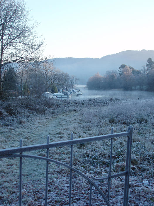 a cold morning looking out over a meadow to lake windermere