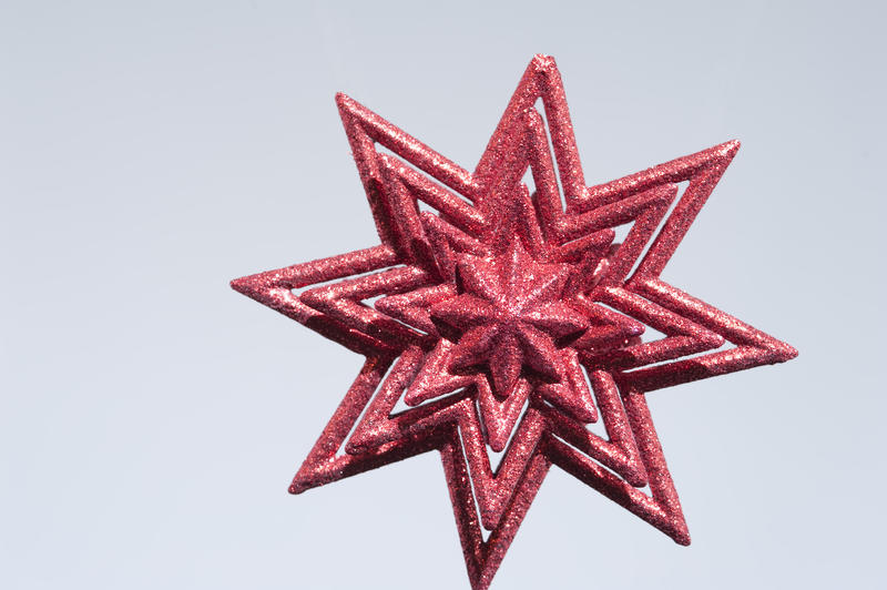 a sparkling christmas star decoration on a grey backdrop