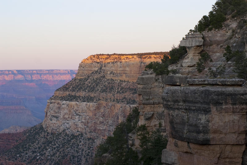 golden light falling on the routh rim of the grand canyon as the sunset