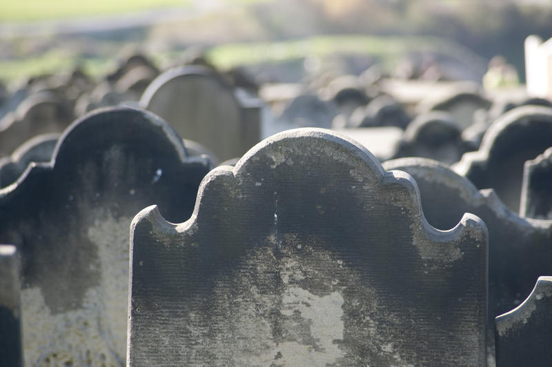 rows of old head stones in a cemetery