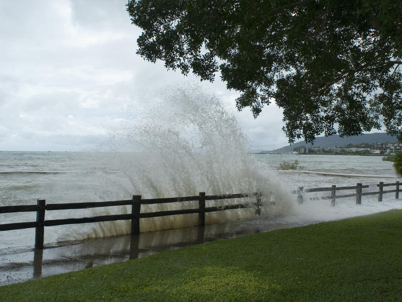 waves breaking over a seawall during a high tide