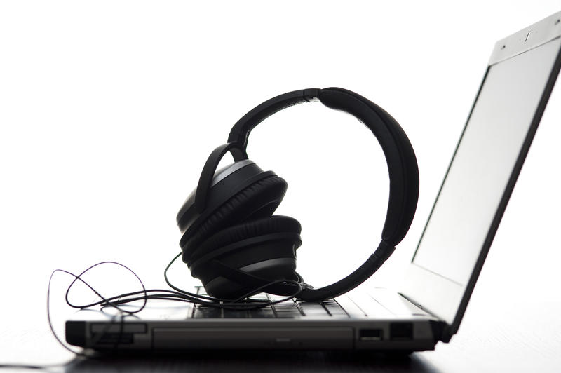 a pair of stereo headphones laid on a laptop keyboard