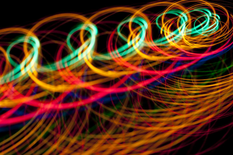 a curled tangle of twisting colored light trails