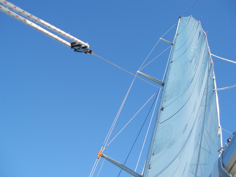 a clear blue sky with a yacht sail, mast and space for text