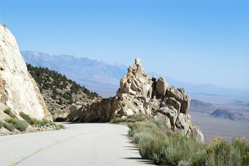a mountain road high in the mountains overlooking a desert plane