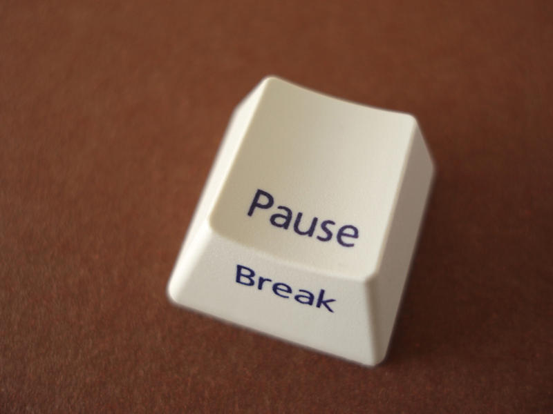 a pause break key removed from a computer keyboard on a brown backdrop