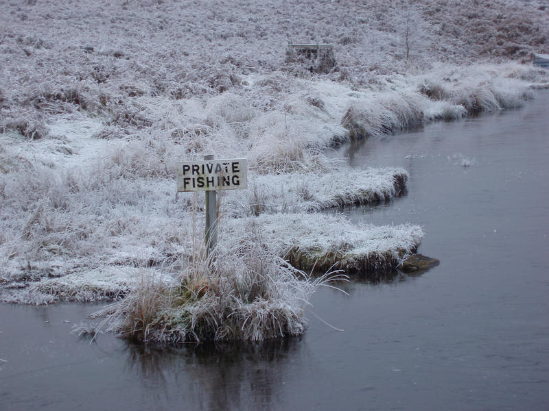 a private fishing sign by a frozen lake