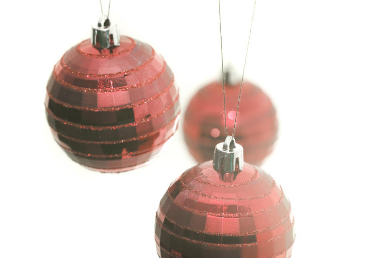 a high key image of three red hanging christmas balls